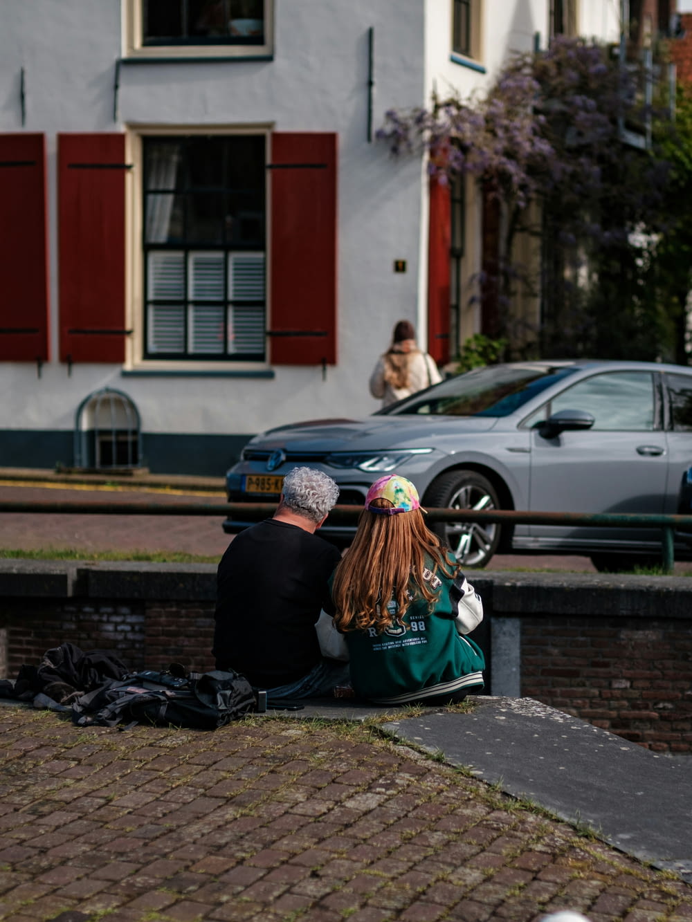a man and a woman sitting on a bench in front of a building