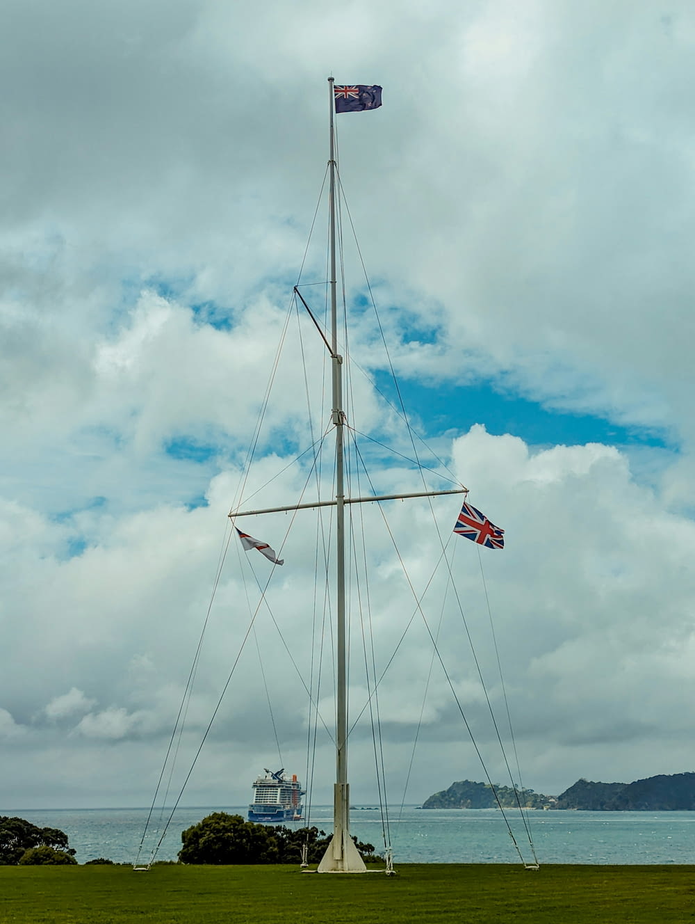 a tall mast with two flags on top of it
