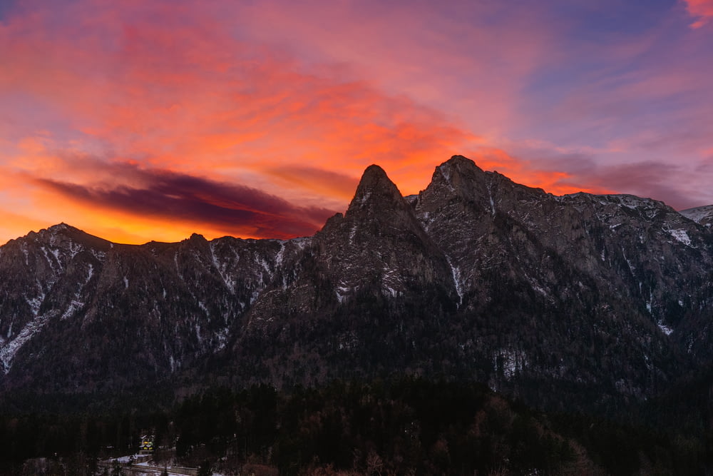 a sunset view of a mountain range with a red sky