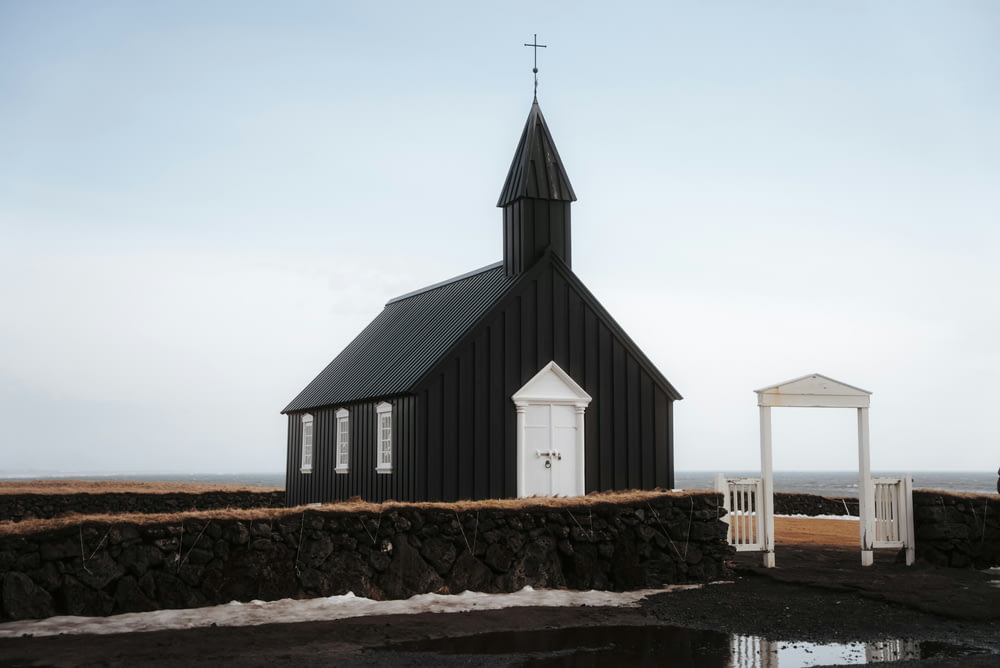 a small black church with a white door