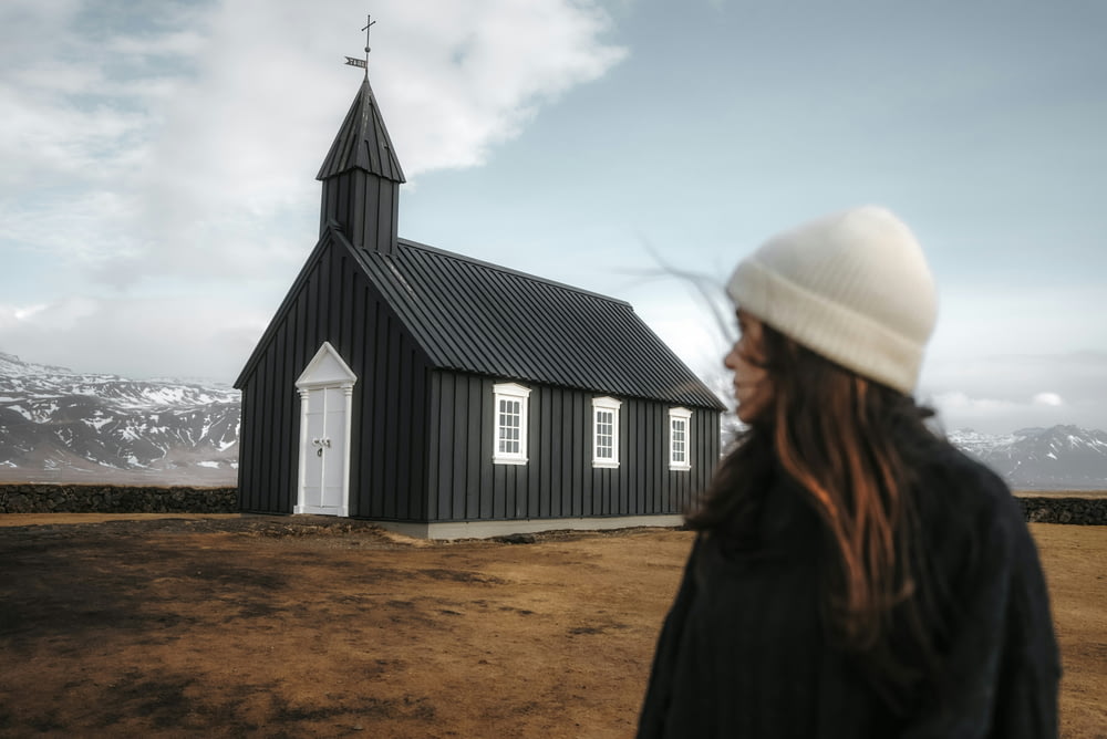 a woman standing in front of a black church