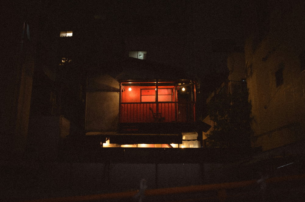 a small building lit up at night in the dark