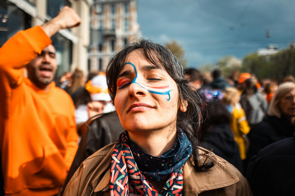 a woman with face paint and a scarf around her neck