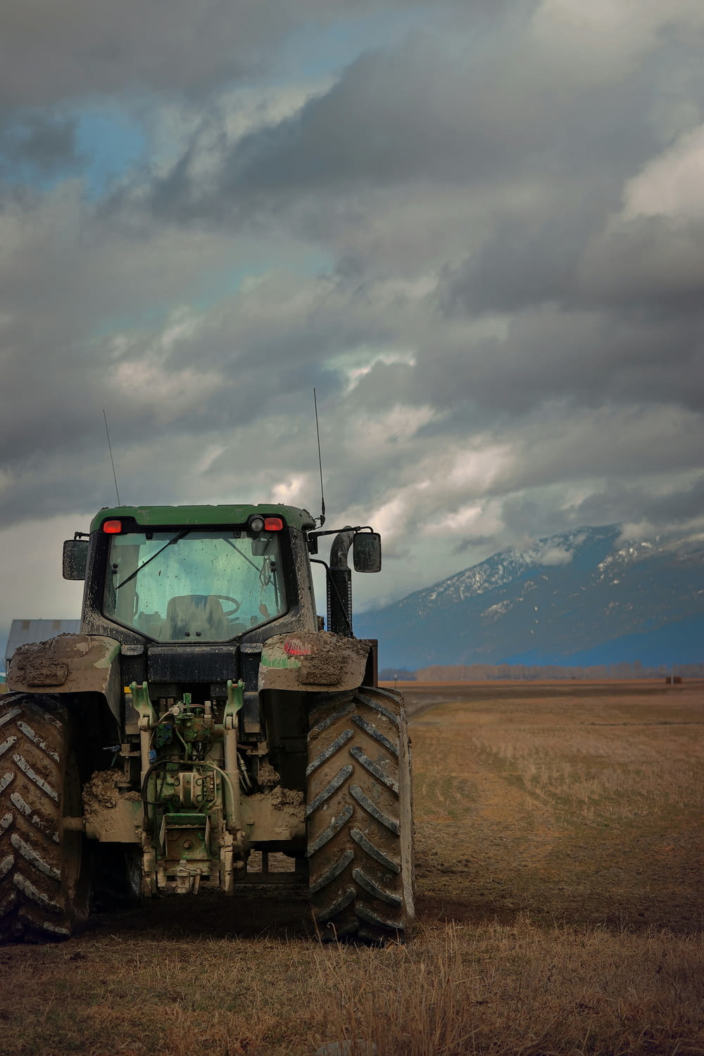 a tractor is parked in a field with mountains in the background