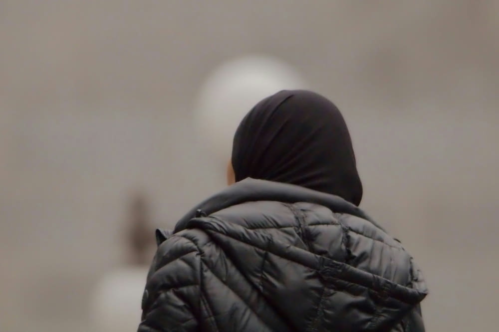 a blurry image of a person in a black jacket