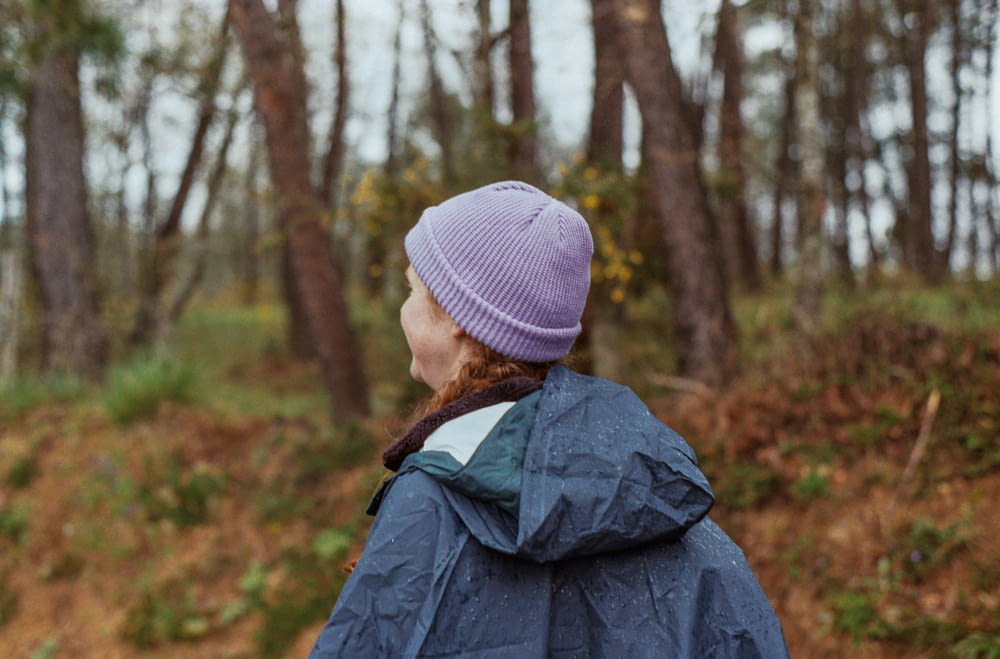 a woman in a blue jacket and a purple hat