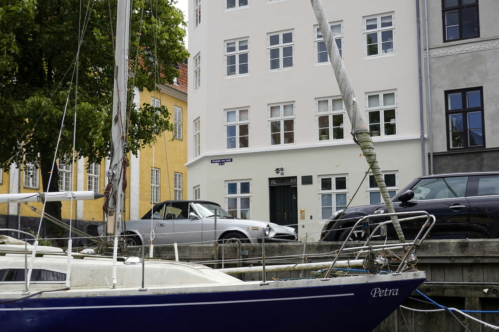 a blue and white boat parked in front of a white building