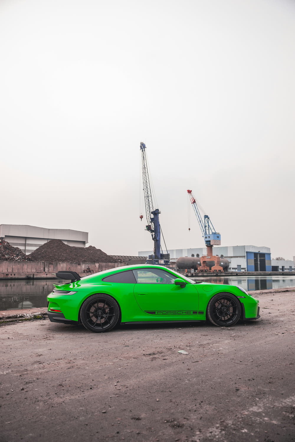 a green sports car parked in front of a construction site