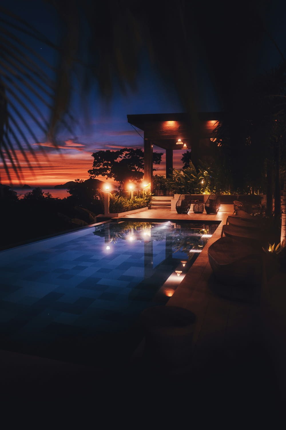 une piscine la nuit avec des lumières allumées