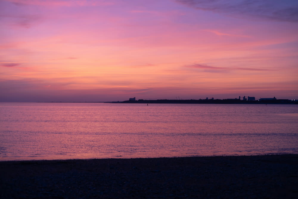 a pink and purple sunset over a body of water