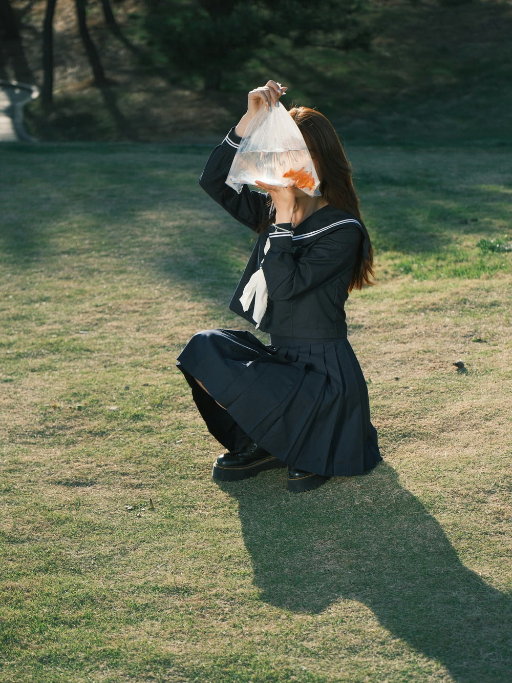 a woman sitting on the ground with a bag over her head