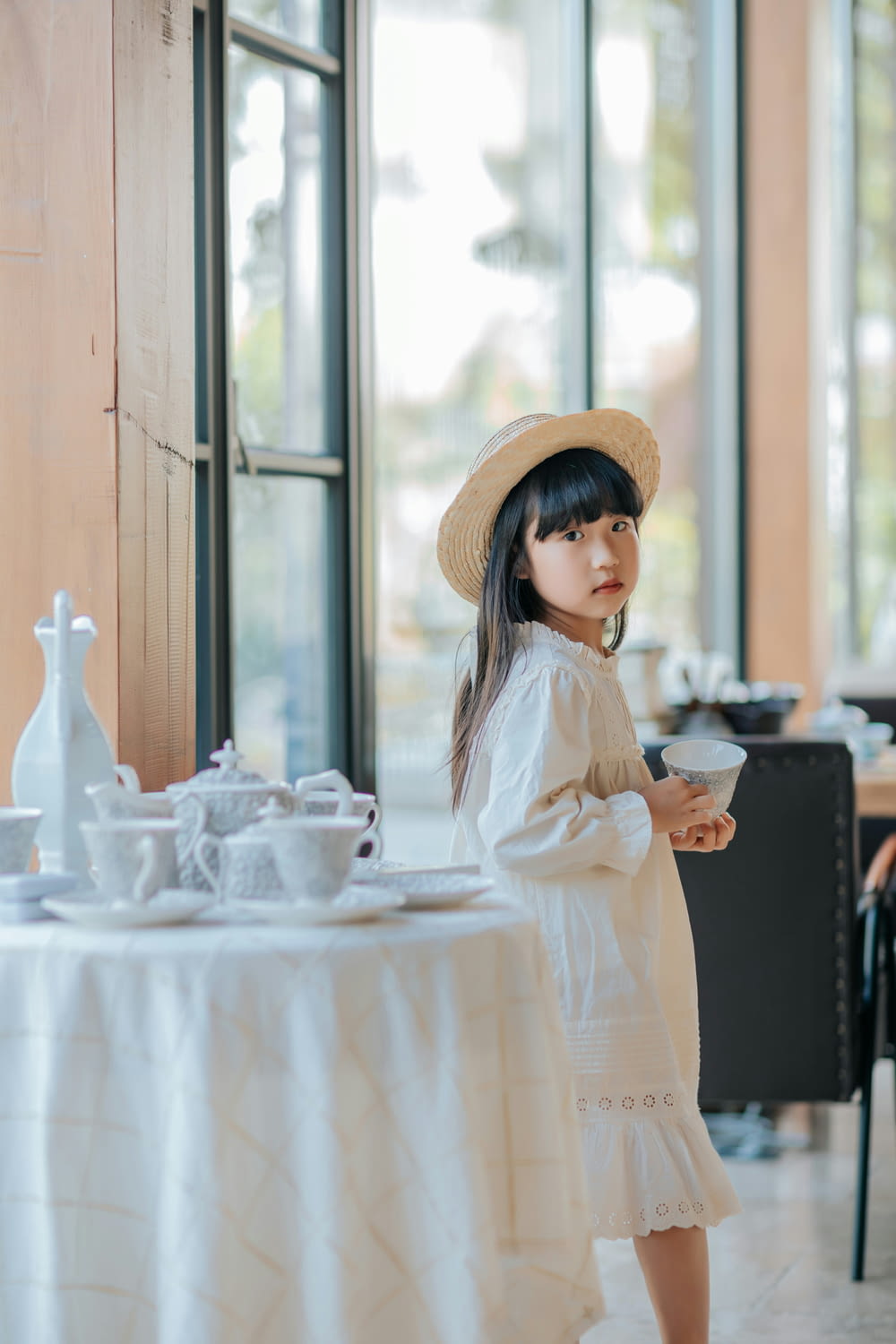 a little girl standing in front of a table