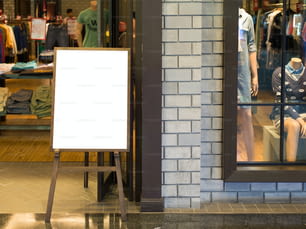 Leeres Holzschild mit Kopierplatz für Ihre SMS oder Inhalte in einem modernen Einkaufszentrum.
