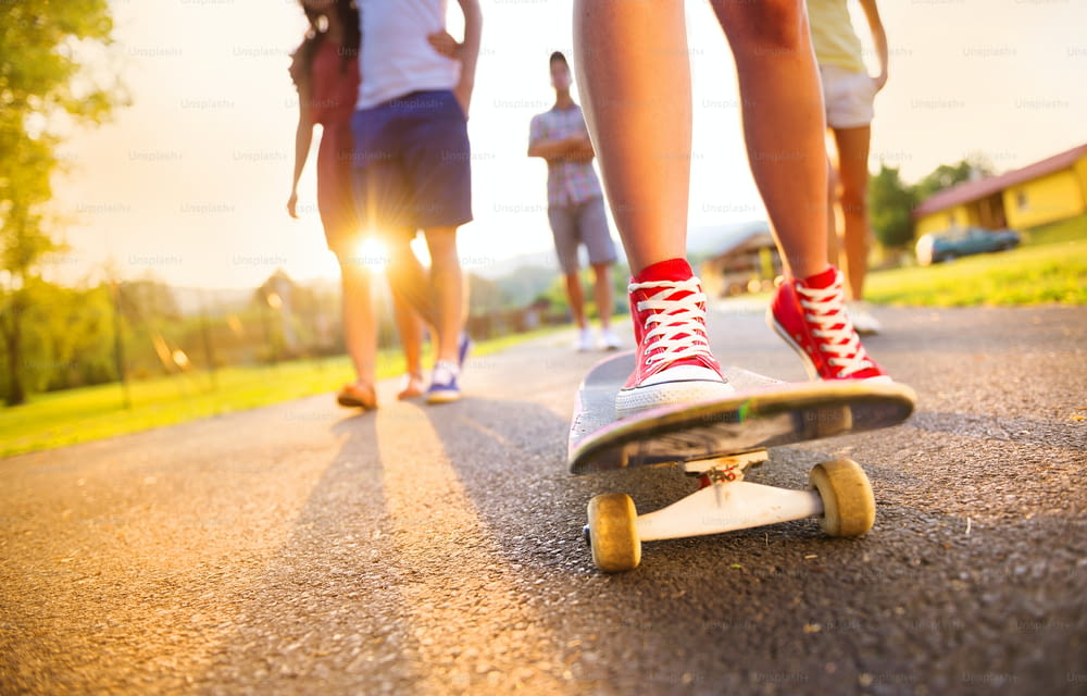 Closeup of legs and sneakers of young people on skateboard