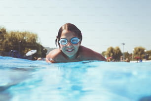 Diversión bajo el agua. Linda niña con gafas nadando bajo el agua y buceando en la encuesta de natación. Deporte y ocio.