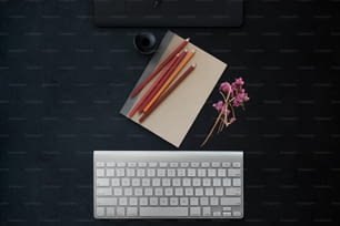 Concept d’espace de travail minimal. Des trucs créatifs, un ordinateur et une tablette graphique numérique sur une table de bureau moderne à surface sombre.