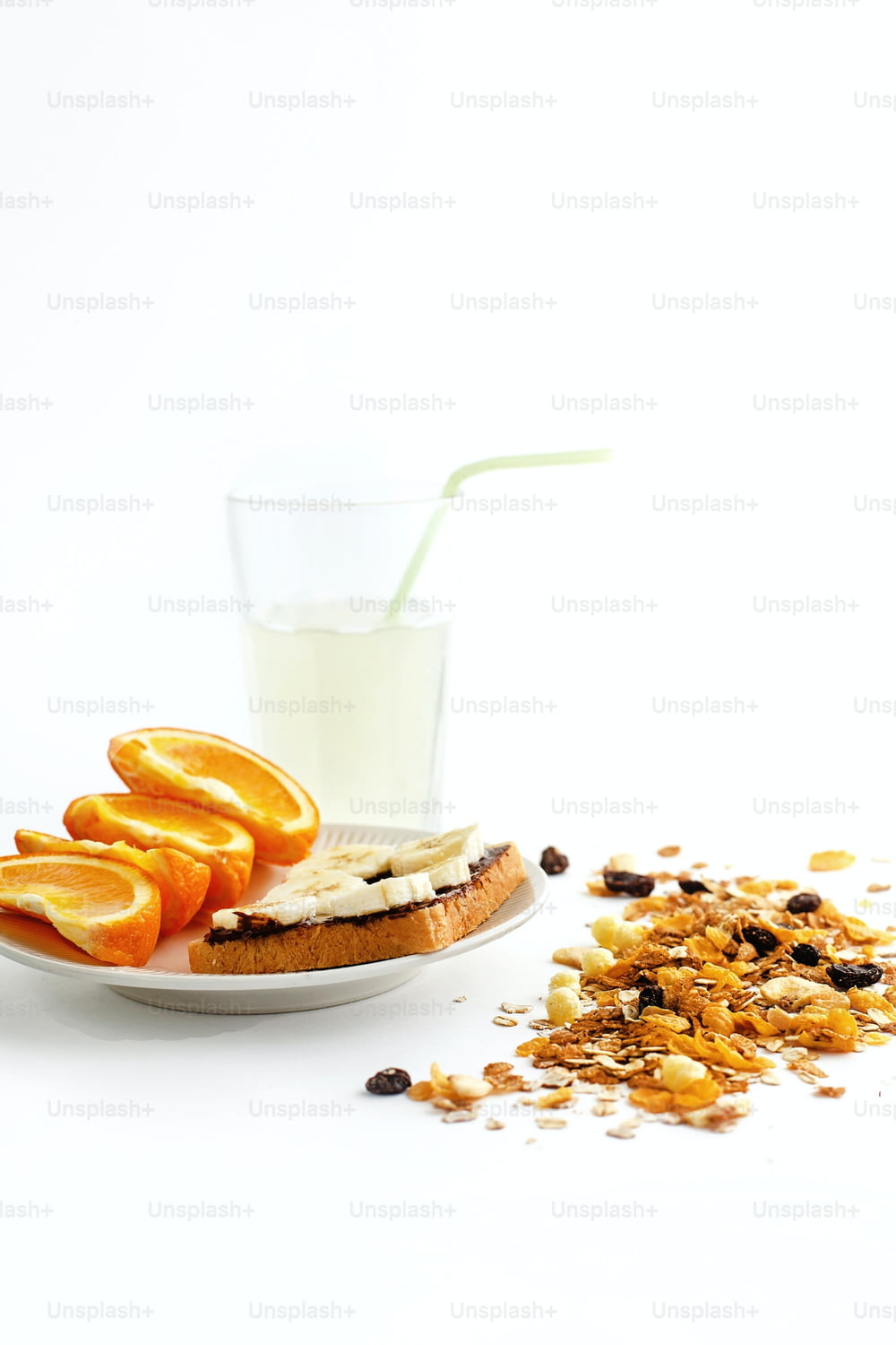 delicious juicy oranges and banana on bread with chocolate and fresh drink and granola  on white background, health eating concept