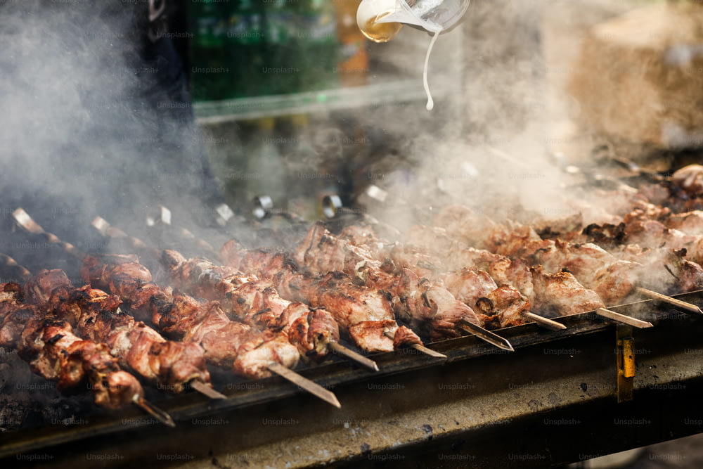 Délicieux barbecue kebab grillades sur gril ouvert, cuisine extérieure. Festival de la nourriture dans la ville. Rôtissage de plats savoureux sur des brochettes, aire de restauration. Pique-d’été