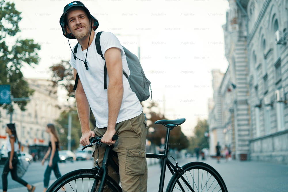 Un homme faisant du vélo dans une vieille ville européenne en plein air. Style de vie, transport écologique, concept de personnes.
