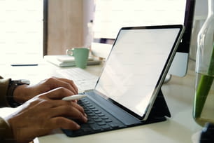 Cropped shot of young man using digital tablet with smart keyboard