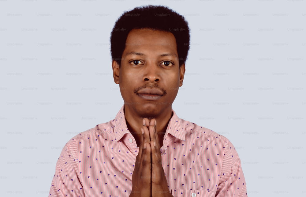 Porträt eines afroamerikanischen Mannes, der im Studio betet.