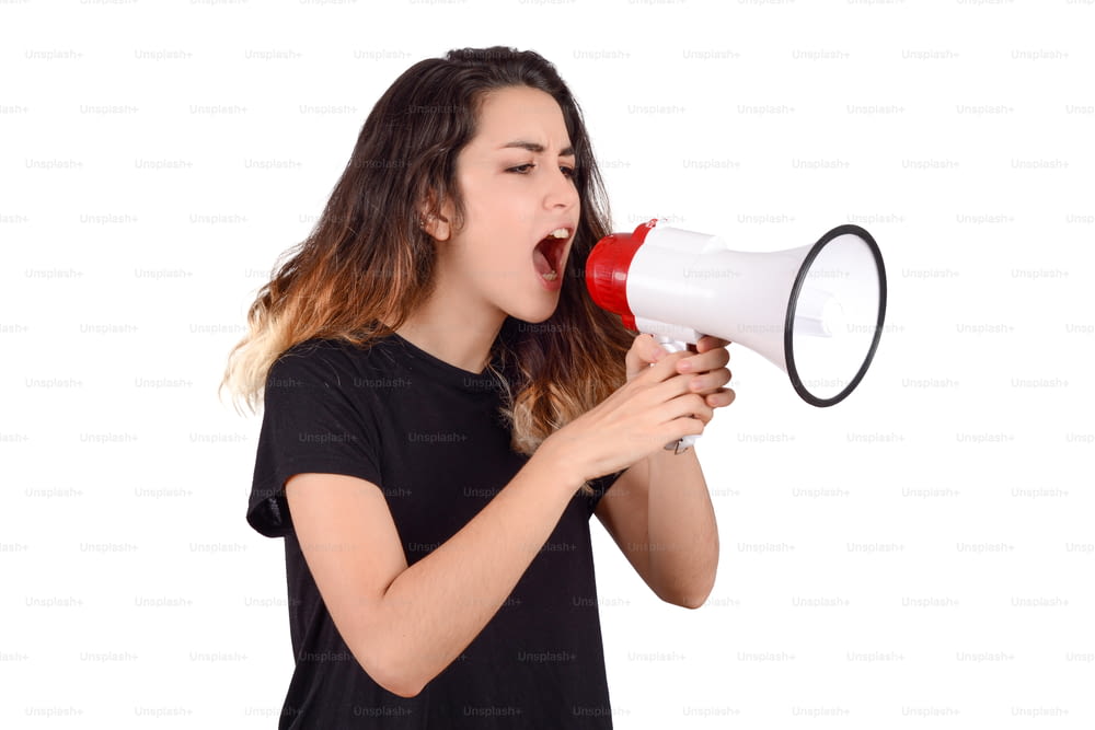 Retrato da mulher jovem gritando em um megafone. Conceito de marketing ou vendas.
