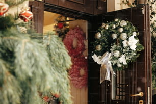 Decoração de rua de Natal. Elegante coroa de Natal com ornamentos de prata na porta na loja da frente no mercado de férias na rua da cidade. Espaço para texto. Decoração rústica