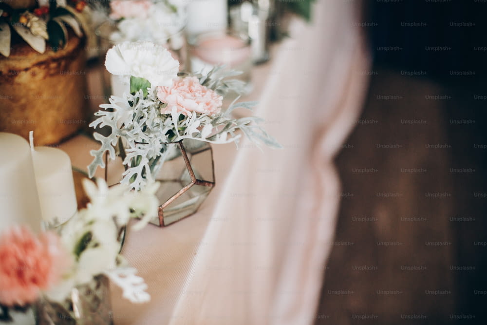 結婚式のテーブルにスタイリッシュで豪華な装飾。ピンクのセンターピースにモダンなガラスの花瓶に白い花が飾られています。贅沢なケータリングと装飾。休日のごちそう
