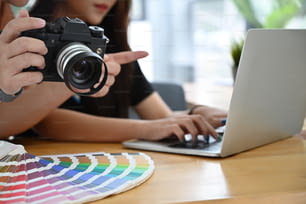 Fotografo e partner che lavorano con il computer portatile e il concetto di colorazione.