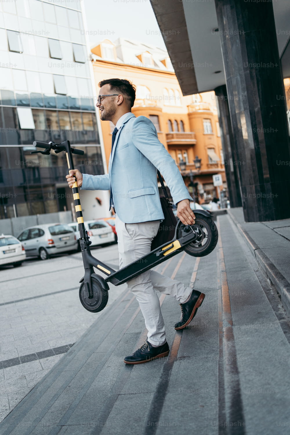 Young modern man using and driving electric scooter on city street. Modern and ecological transportation concept.
