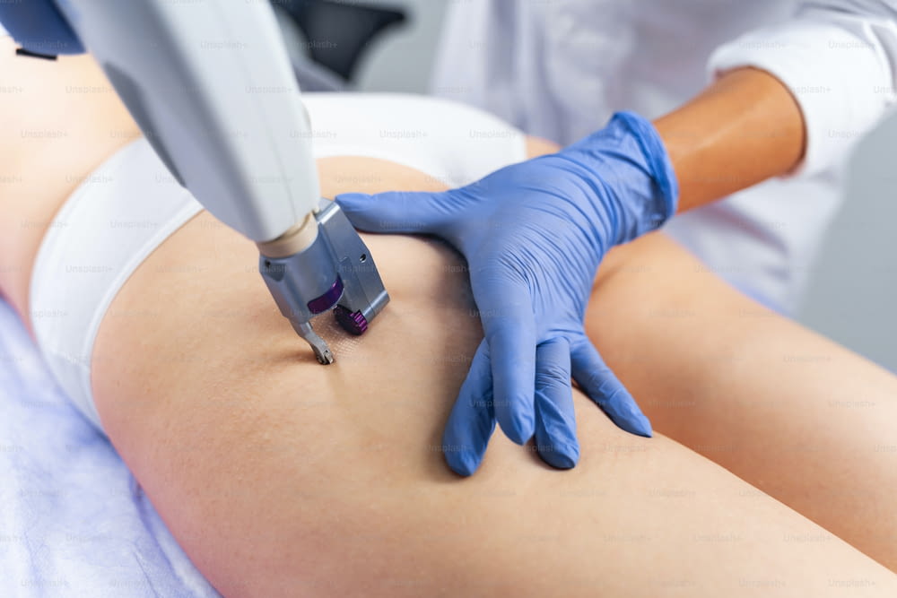 Dermatologist carrying out a non-invasive procedure on a young female patient in a beauty salon