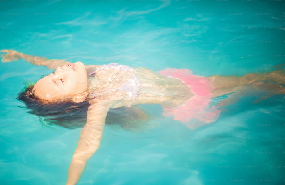 Einfach entspannen und genießen. Kleines Mädchen schwimmt im Pool.