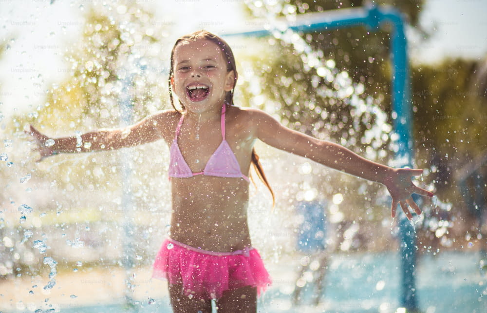 Der Sommer ist so tolle Jahreszeit. Kleines Mädchen spielt im Pool. Blick in die Kamera.