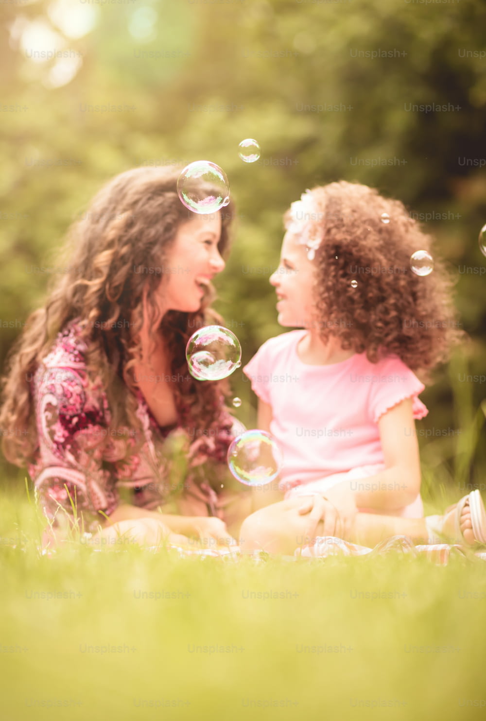Tiempo de burbujas. Madre e hija en la naturaleza. La atención se centra en la burbuja.