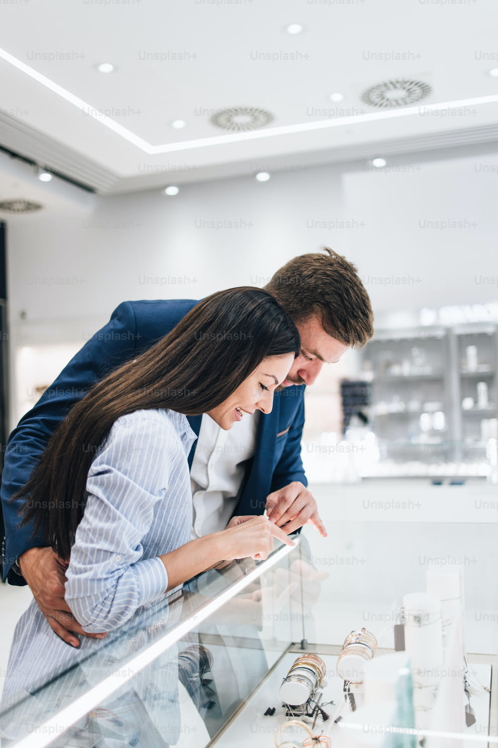 Schönes Paar, das beim Einkaufen im modernen Juweliergeschäft genießt.