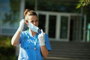 코로나 바이러스 전염병. 병원 근처 야외에서 청진기�와 의료용 마스크를 쓴 현대 의료 종사자 여성.