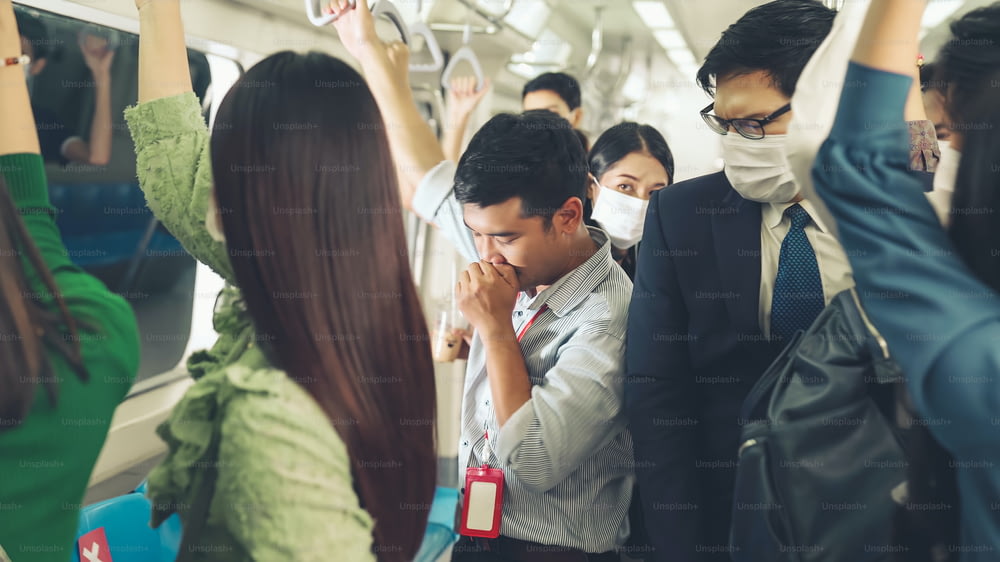 Sick man on train cough and make other people feel worry about virus spreading . Coronavirus COVID 19 pandemic and public transportation trouble concept .