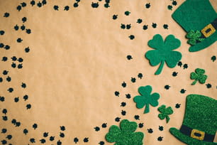Happy Saint Patrick's Day Konzept. Flache Lay-Komposition mit grünen Hüten und Kleeblattblättern auf Kraftpapierhintergrund. St Patrickâs Day Bannerdesign, Postervorlage.