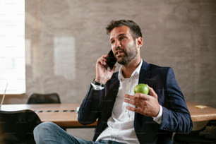 Uomo d'affari nella sala conferenze usando il telefono. Bel uomo d'affari che parla al telefono.