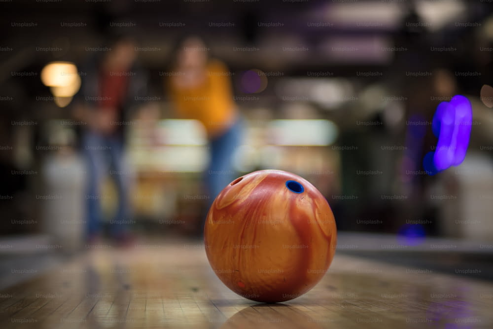 Young couple having fun in bowling alley.  Focus is on bowler.