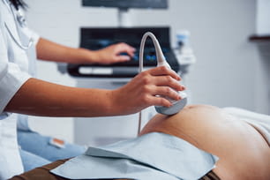 여성 의사는 병원에서 임산부를 위해 초음파 검사를합니다.