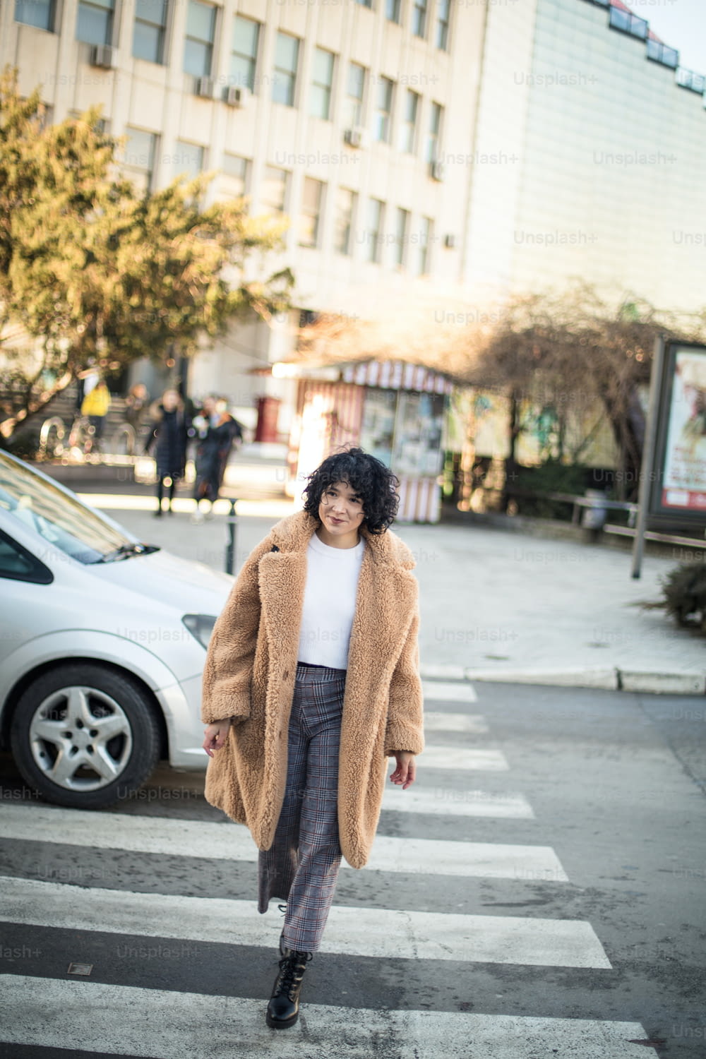 Mujer sonriente cruzando la calle.