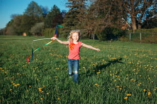 공원에서 리본을 가지고 노는 행복한 아이 소녀. 초원에서 함께 노는 귀여운 사랑스러운 아이. 아이들을 위한 야외 여름 뒷마당 활동. 청순한 어린 시절 솔직한 정통 생활 방식.