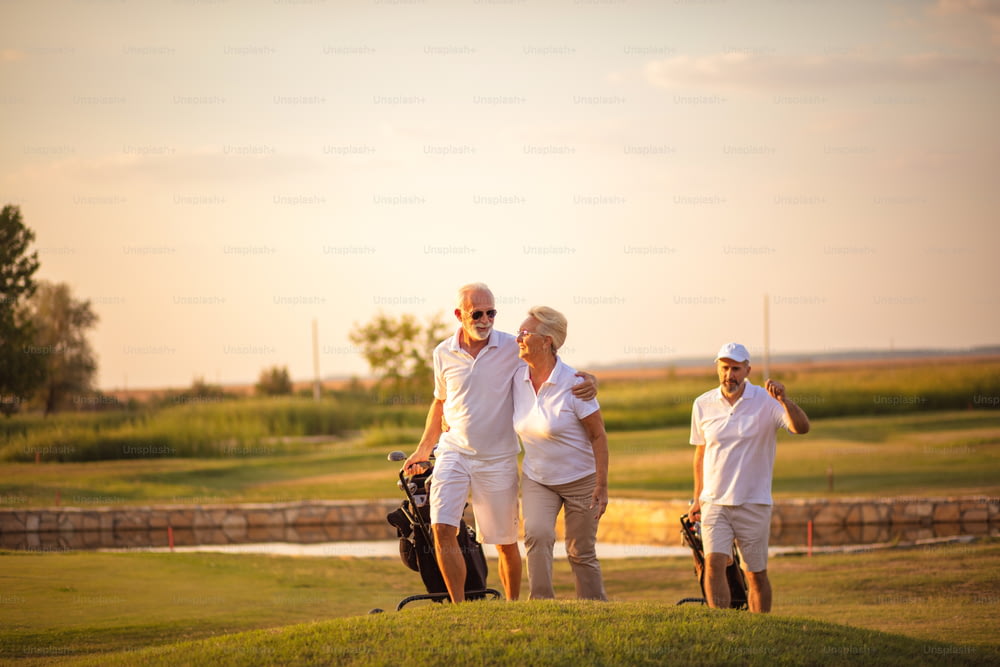 Three senior golfers. Focus is on man and woman.