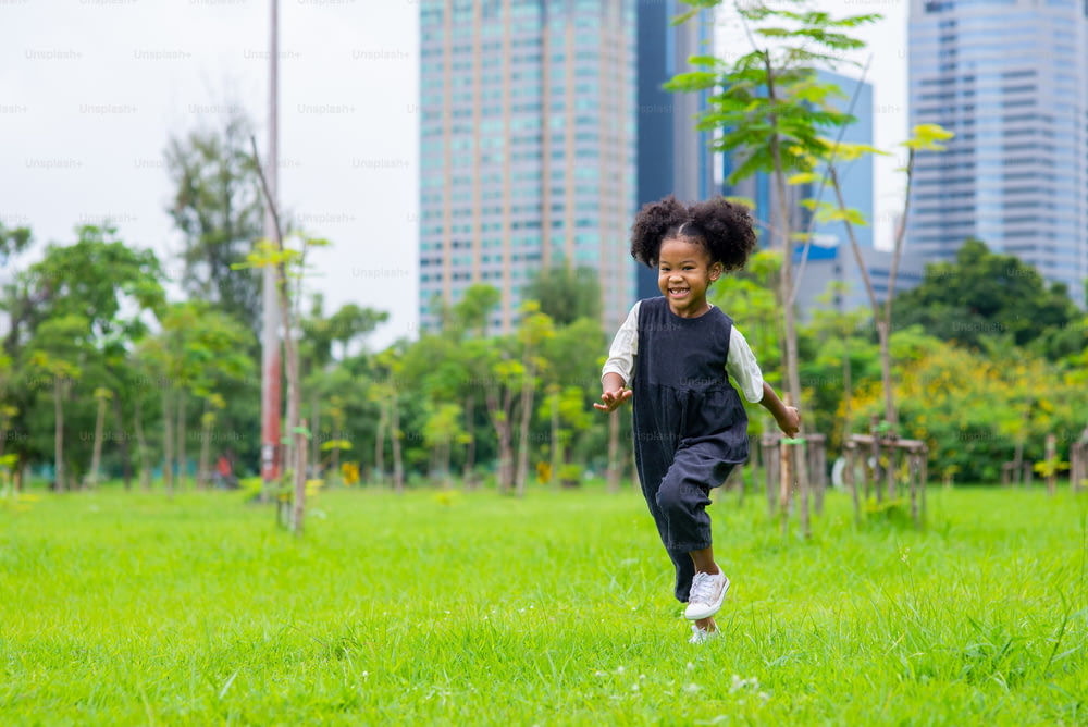 Happy mixed race family in park. Adorable child girl kid running and playing in public park. Smiling little daughter enjoy and having fun outdoor lifestyle activity summer weekend vacation.