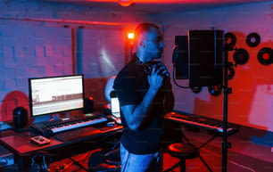 Le chanteur a une session d’enregistrement à l’intérieur dans le studio professionnel moderne.