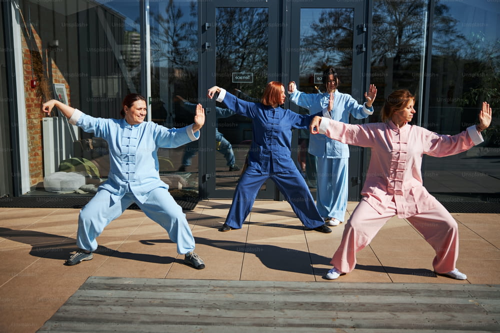 Several ladies doing their best while getting the philosophy of qigong and doing exercises