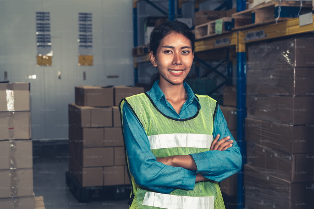 Portrait of young woman warehouse worker smiling in the storehouse . Logistics , supply chain and warehouse business concept .