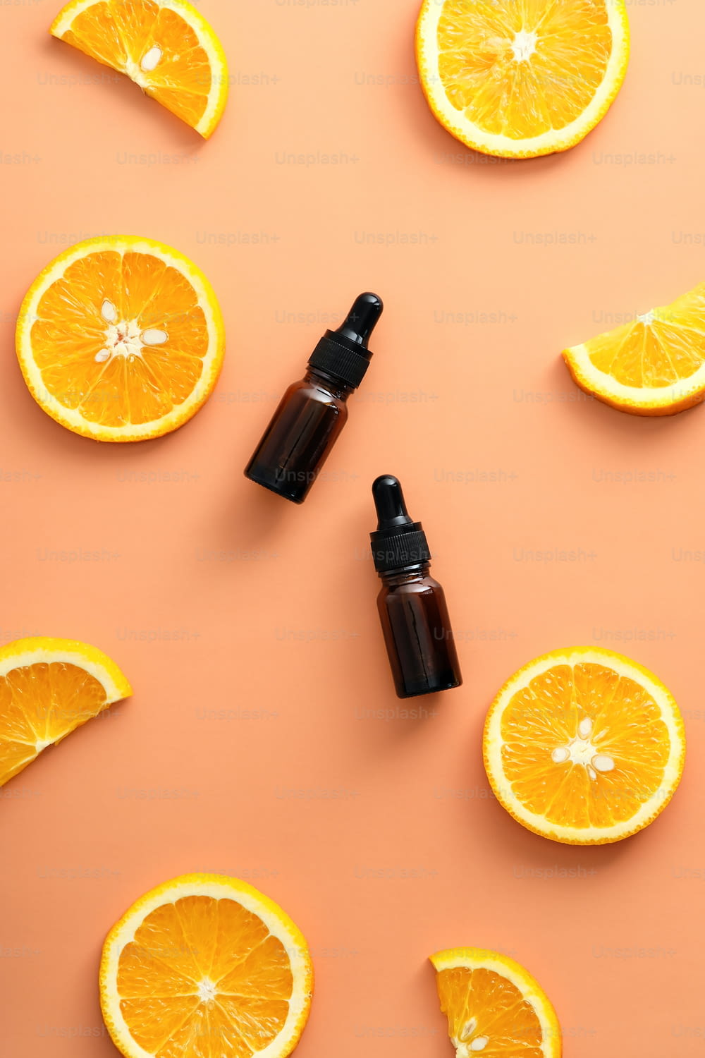 Frascos conta-gotas de soro de vitamina C com vista superior laranja fatiada. Design de produtos de beleza natural.