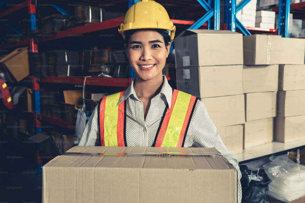 Portrait of young Asian woman warehouse worker smiling in the storehouse . Logistics , supply chain and warehouse business concept .